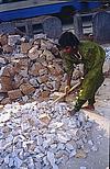 Girl breaking heavy stone with a hammer