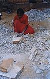 Woman Breaking Hard Stones with Hammer