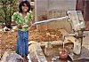 Girl Fetching Water from a Public Pump for Family's Use