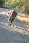 Old Woman Walking on Road