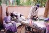 Man Irons Clothes as Customer Waits