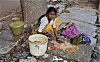 Woman Washing Clothes on a stone pavement