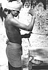 An Adivasi making rope from tree bark