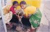 Women Washing at a Roadsite Water Tap