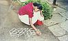 a girl looking in to a book and  drawing rangoli