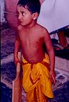 A kid in traditional dress with bat