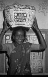 A young woman carrying eatable in painted basket for bhumi puja