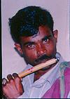 Street beggar playing flute