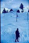 A lone person beside a snow covered road