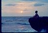 A kid on the rock watching sea