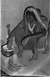 Adivasi woman cooking at the hearth