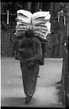 Laborer carrying boxes and parcels, 1985