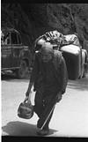 Laborer carrying load on back and even in the hands, 1985