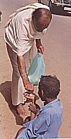 A barefooted Brahmin offers alms to a beggar