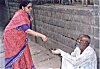 A lady in the process on donating alms