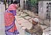 She gives alms to another beggar