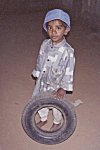 Boy poses with his new found toy - a used scooter tire