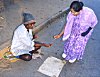 A housewife obliges with a coin.