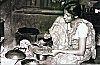 A Konkani Woman Making Pan Cakes on Wooden Stove