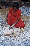 Woman handbreaking granite stone