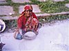 A woman powders chalk for Rangoli