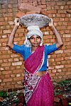 A Construction Worker Carrying Bricks