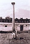 Man sitting under a pillar