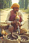 A street side snake charmer dances his cobra