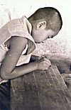 Tibetan Boy Writing on a Wooden Plank